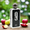 Afnan 9pm perfume bottle with apples on a wooden surface