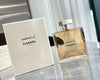 Chanel Gabrielle perfume bottle and packaging on a reflective surface with blurred background