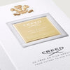 Creed perfume packaging with gold label and logo on a white background