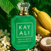 Green perfume bottle labeled 'KAY ALI' with bananas, flowers, and a coconut in the background.