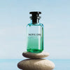 Louis Vuitton Pacific Chill perfume bottle on a stone with a blue background