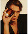 Man holding a perfume bottle labeled 'Diamonds Are You' by Armani.