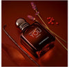 Perfume bottle labeled 'Stronger with You' by Emporio Armani on a red background with flowers.