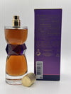 Perfume bottle with geometric design and gold cap next to its packaging on a white background