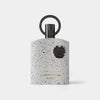 Perfume bottle with speckled design and black cap on a white background