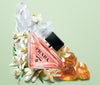 Prada perfume bottle with flowers and crystals on a light green background
