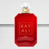 Red perfume bottle with gold cap on a textured white background